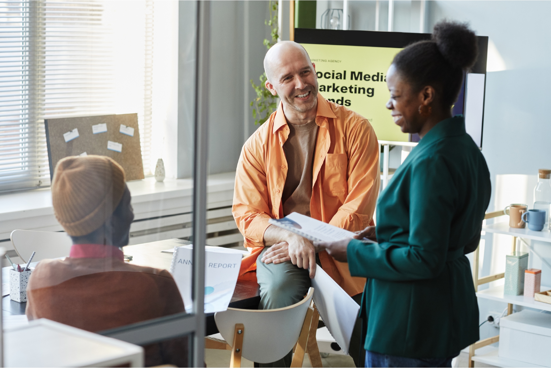 Team reviewing a digital campaign dashboard on screen.